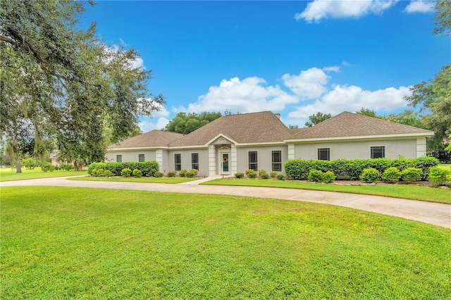 single story home with stucco siding, driveway, a front yard, and a shingled roof