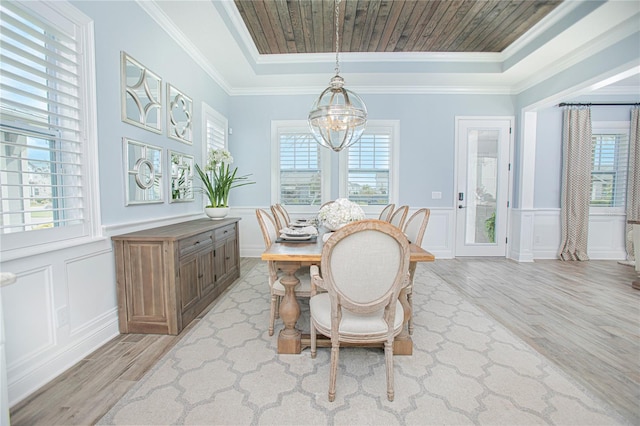 dining area with a healthy amount of sunlight, ornamental molding, and light hardwood / wood-style flooring