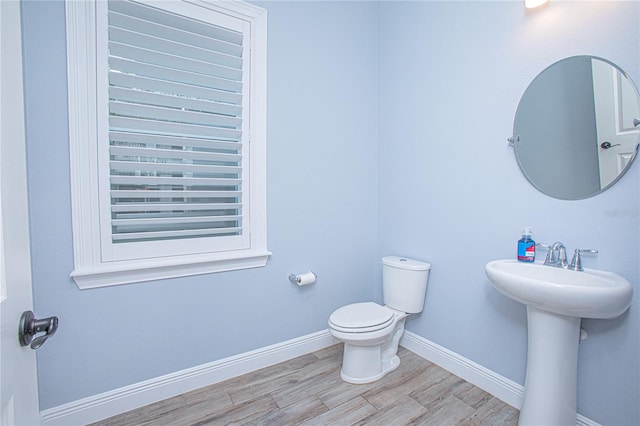 bathroom featuring sink, wood-type flooring, and toilet