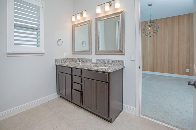 bathroom with tile patterned flooring, vanity, and wood walls