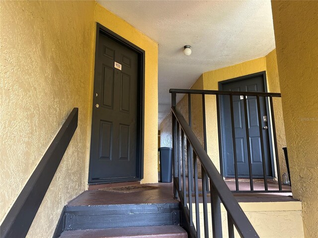 stairway featuring a textured ceiling