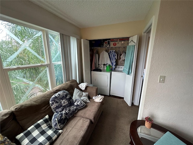 interior space with a textured ceiling, carpet, independent washer and dryer, and a textured wall