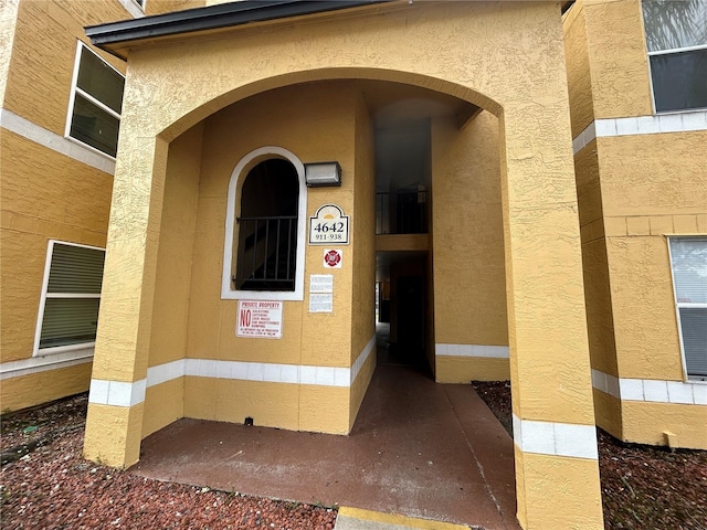 doorway to property featuring stucco siding