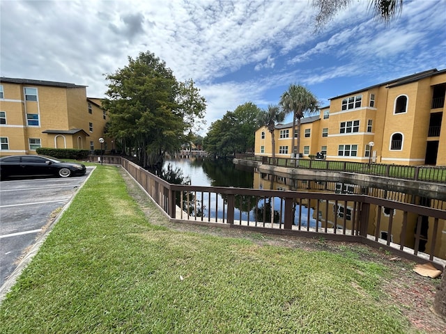 view of dock featuring a water view and a lawn