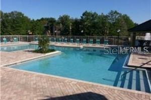 pool with a patio and fence