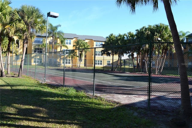 view of sport court with a yard and fence