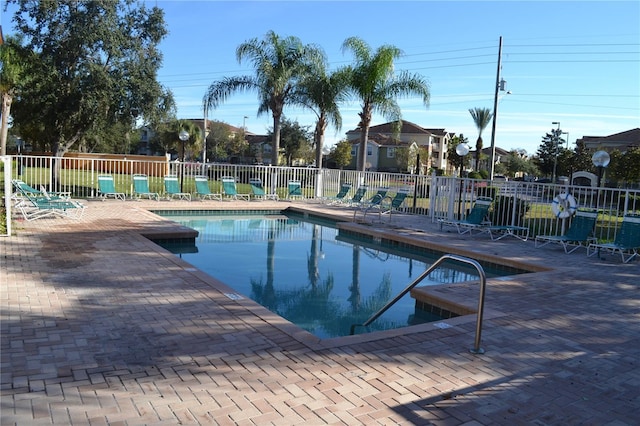 community pool with a patio and fence