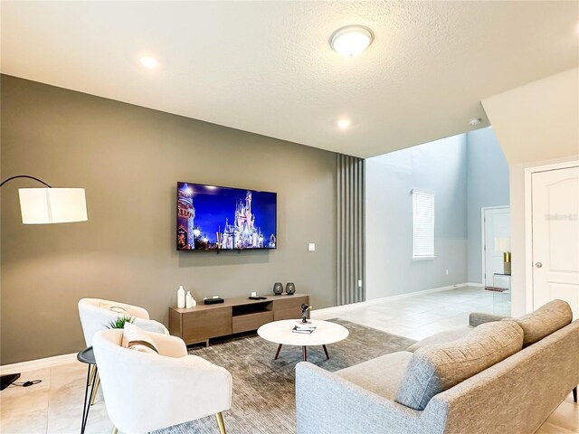 living room with a textured ceiling and light tile patterned floors