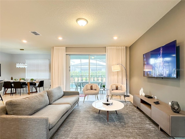 living room with visible vents, a textured ceiling, and recessed lighting