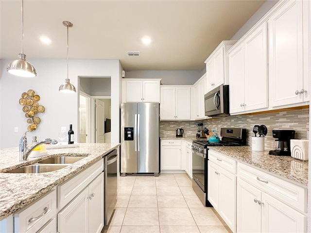 kitchen featuring light tile patterned floors, appliances with stainless steel finishes, tasteful backsplash, sink, and white cabinetry