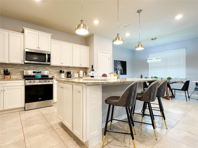 kitchen with light tile patterned floors, stainless steel appliances, tasteful backsplash, and visible vents