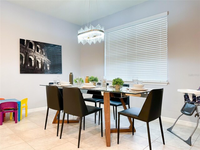 dining area with light tile patterned floors and a chandelier