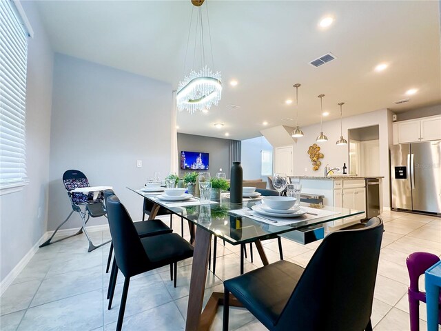 tiled dining space with sink and a chandelier