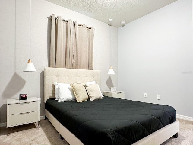 bedroom featuring a textured ceiling, carpet, and baseboards