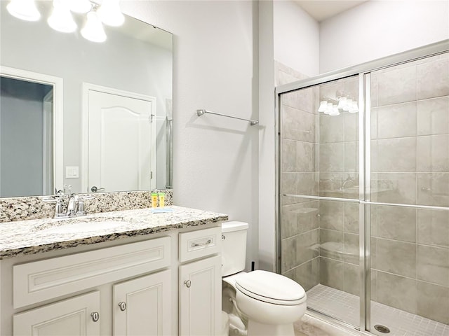 full bath with vanity, a shower stall, and toilet