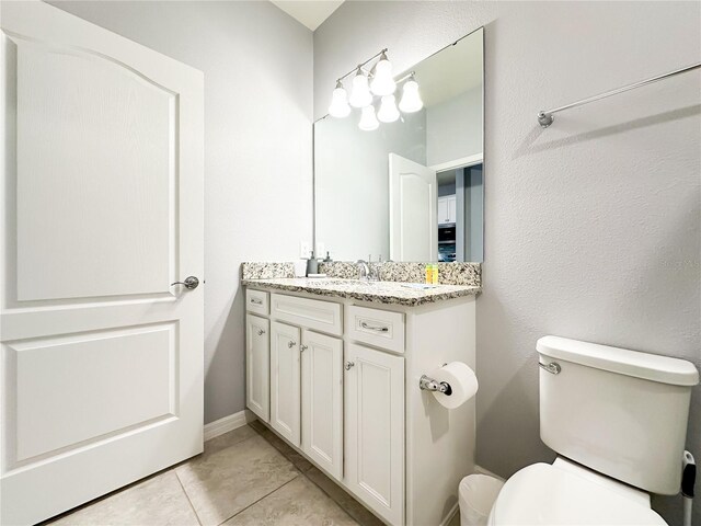 bathroom with tile patterned flooring, vanity, and toilet