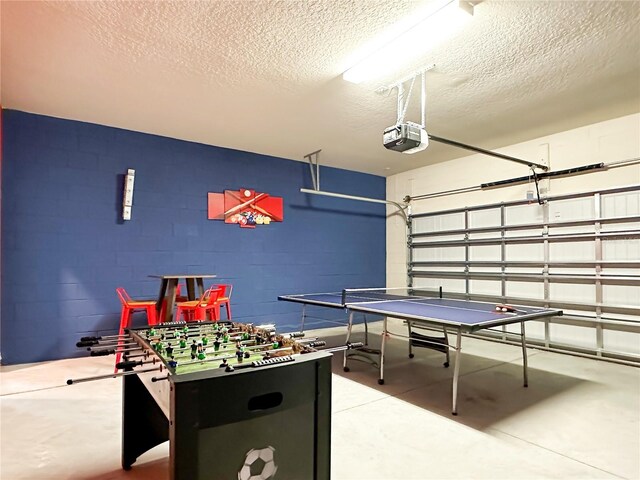 playroom with a textured ceiling and concrete floors