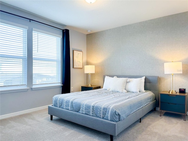 bedroom with baseboards and light colored carpet