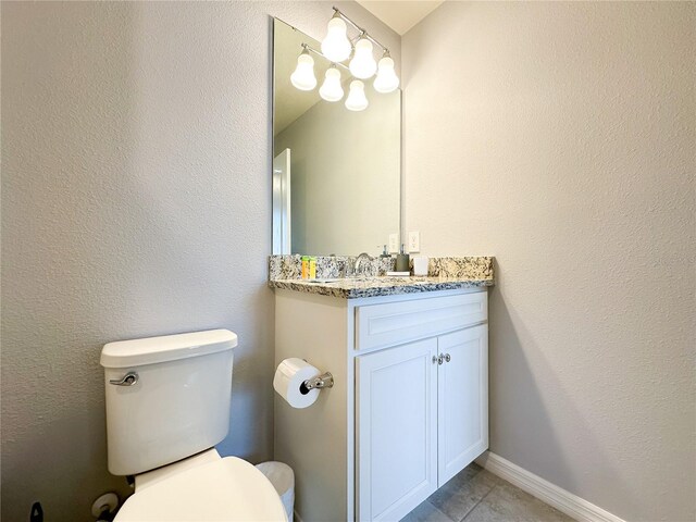 bathroom featuring tile patterned flooring, vanity, and toilet