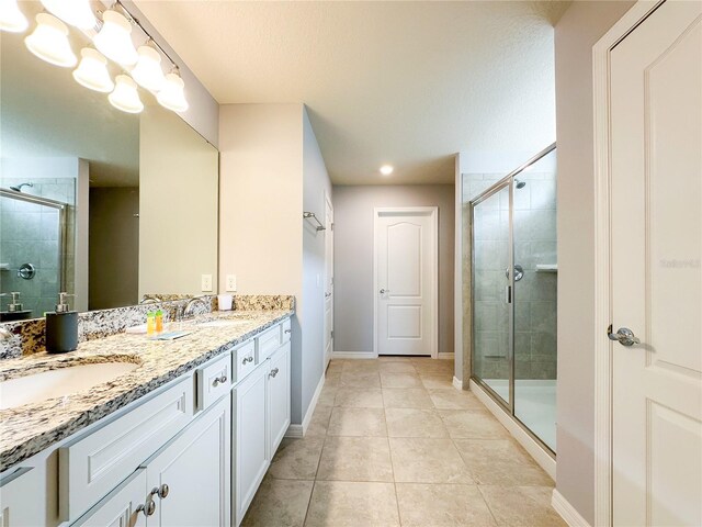 bathroom with vanity, walk in shower, and tile patterned flooring