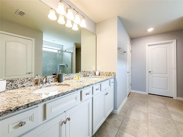 bathroom with vanity, an enclosed shower, and tile patterned floors