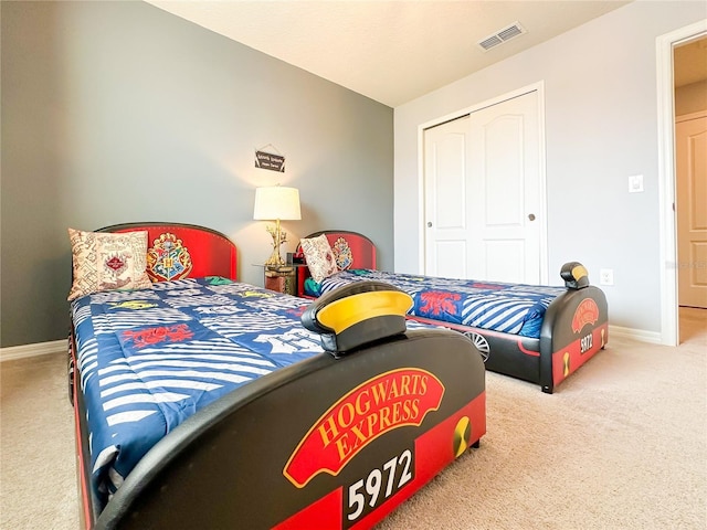 bedroom with a closet, carpet, visible vents, and baseboards