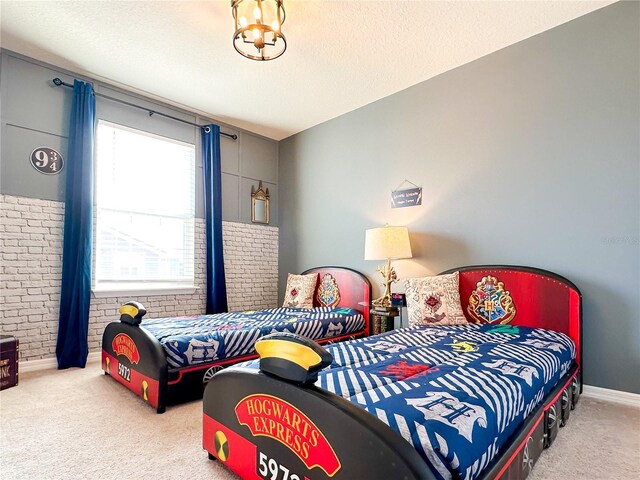 bedroom with a textured ceiling, carpet flooring, and a chandelier