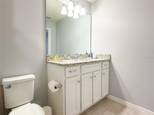 bathroom featuring tile patterned flooring, toilet, and vanity