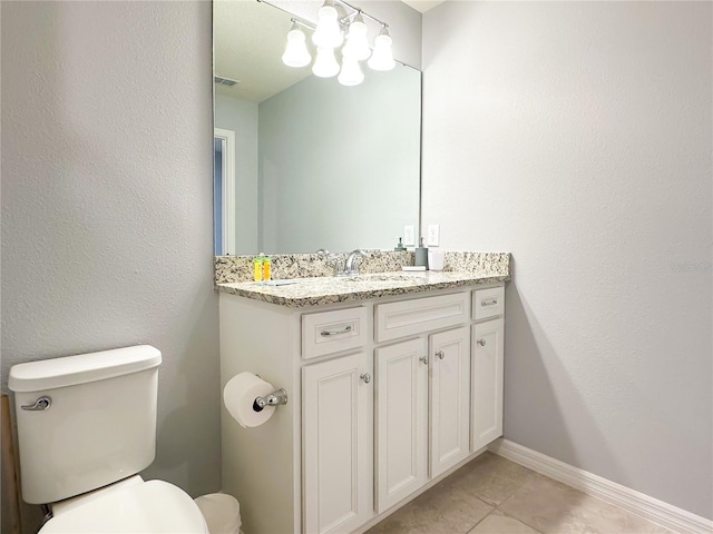 half bath featuring toilet, visible vents, baseboards, vanity, and tile patterned floors