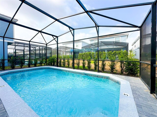 view of pool featuring glass enclosure