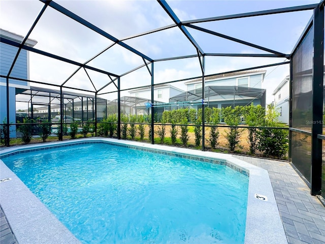 pool featuring a patio area and glass enclosure