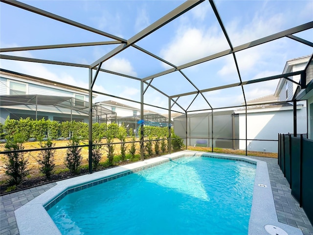 pool with glass enclosure and a patio area