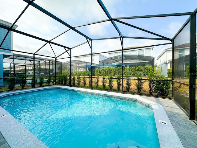 outdoor pool featuring a patio area and glass enclosure