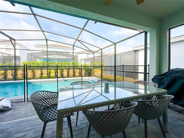 outdoor pool featuring a patio area, outdoor dining area, glass enclosure, and grilling area