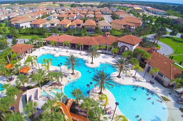 community pool with a residential view and a patio area