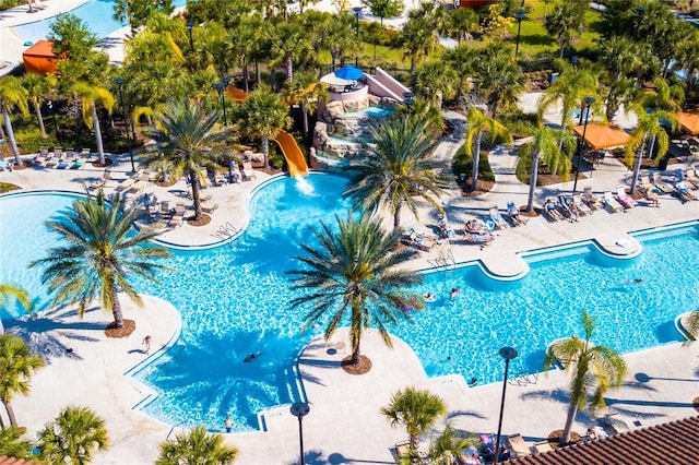 community pool with a patio and a water slide