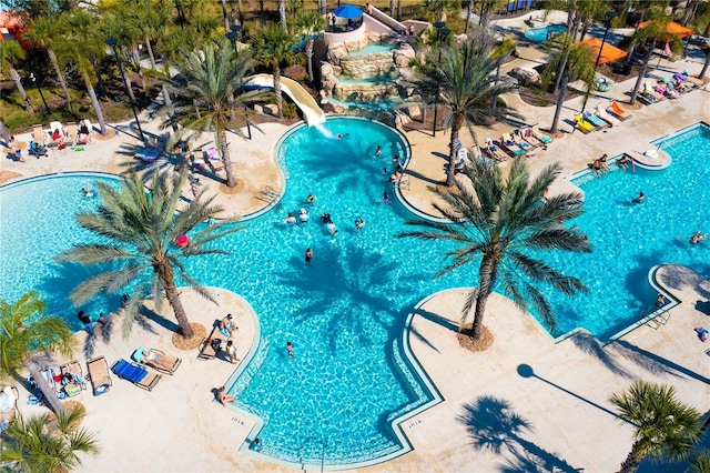 community pool with a water slide and a patio area