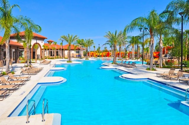 pool with a water slide and a patio area