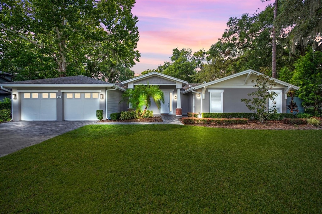 ranch-style home featuring a yard and a garage