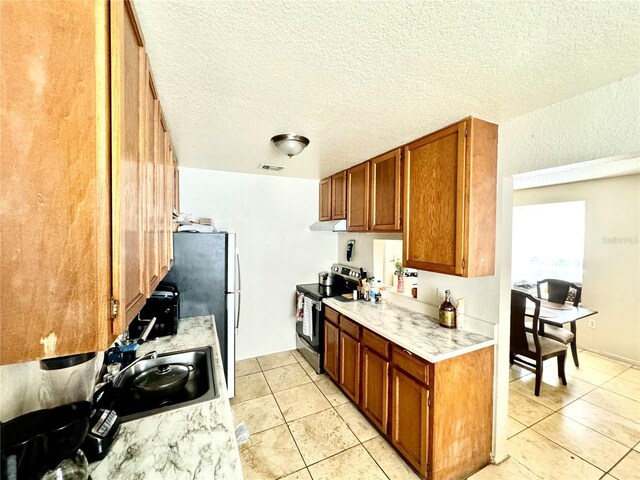 kitchen with light countertops, visible vents, electric stove, and light tile patterned flooring