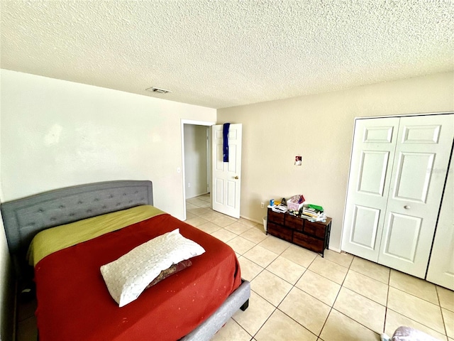 tiled bedroom featuring a textured ceiling and a closet