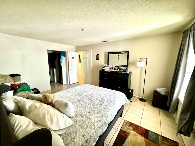 tiled bedroom featuring a textured ceiling