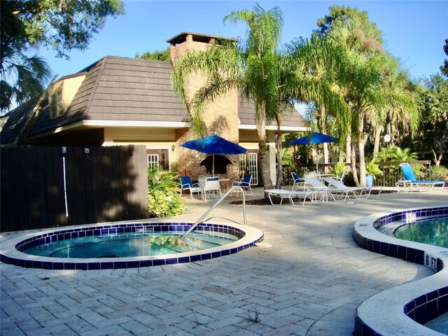 pool featuring a community hot tub and a patio