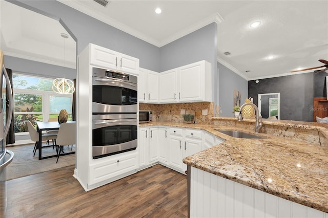 kitchen with sink, decorative light fixtures, stainless steel double oven, light stone countertops, and white cabinets