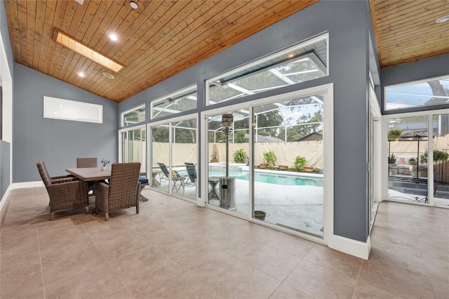 sunroom featuring lofted ceiling with skylight and wooden ceiling