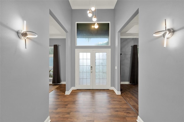 foyer entrance with crown molding, dark hardwood / wood-style floors, and french doors