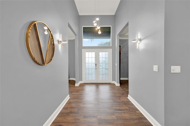 entryway with crown molding, dark wood-type flooring, and french doors