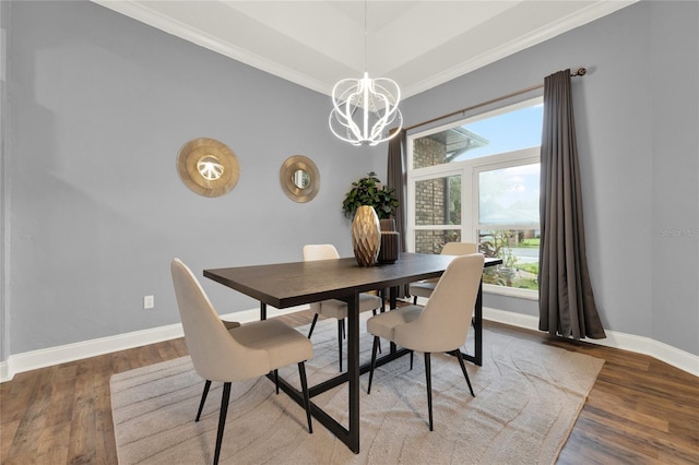 dining area featuring a tray ceiling, a notable chandelier, hardwood / wood-style flooring, and ornamental molding