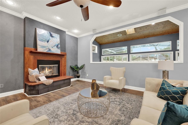 living room with ceiling fan, ornamental molding, and wood-type flooring