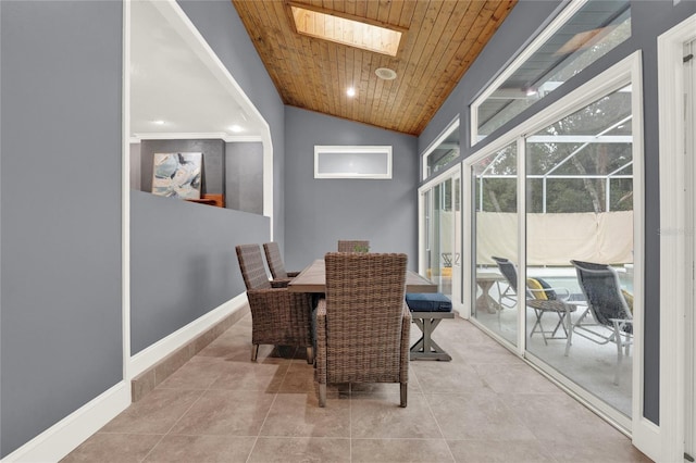 dining area with light tile patterned floors, wood ceiling, and lofted ceiling with skylight